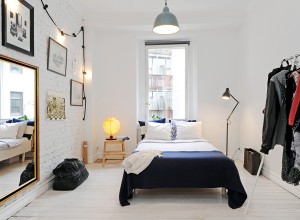 Petite chambre modeste avec grand miroir suspendu