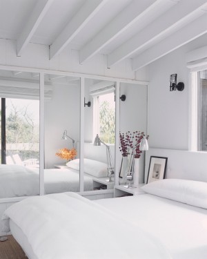 Chambre blanche avec grande armoire à glace blanche